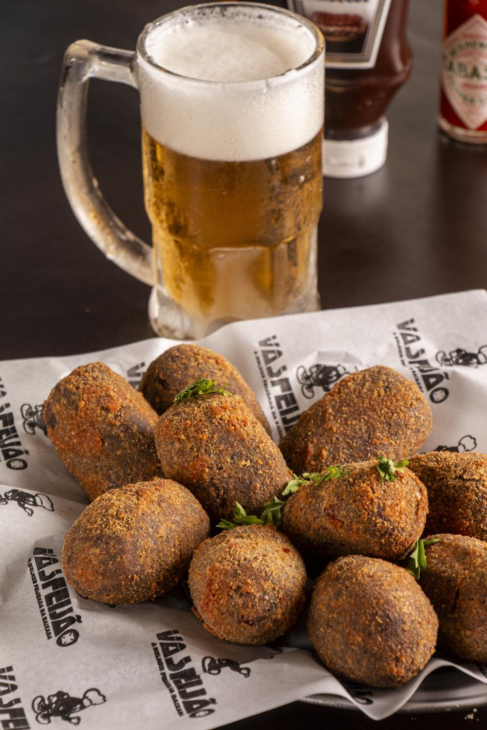 Porção de bolinhos de feijoada com chopp
